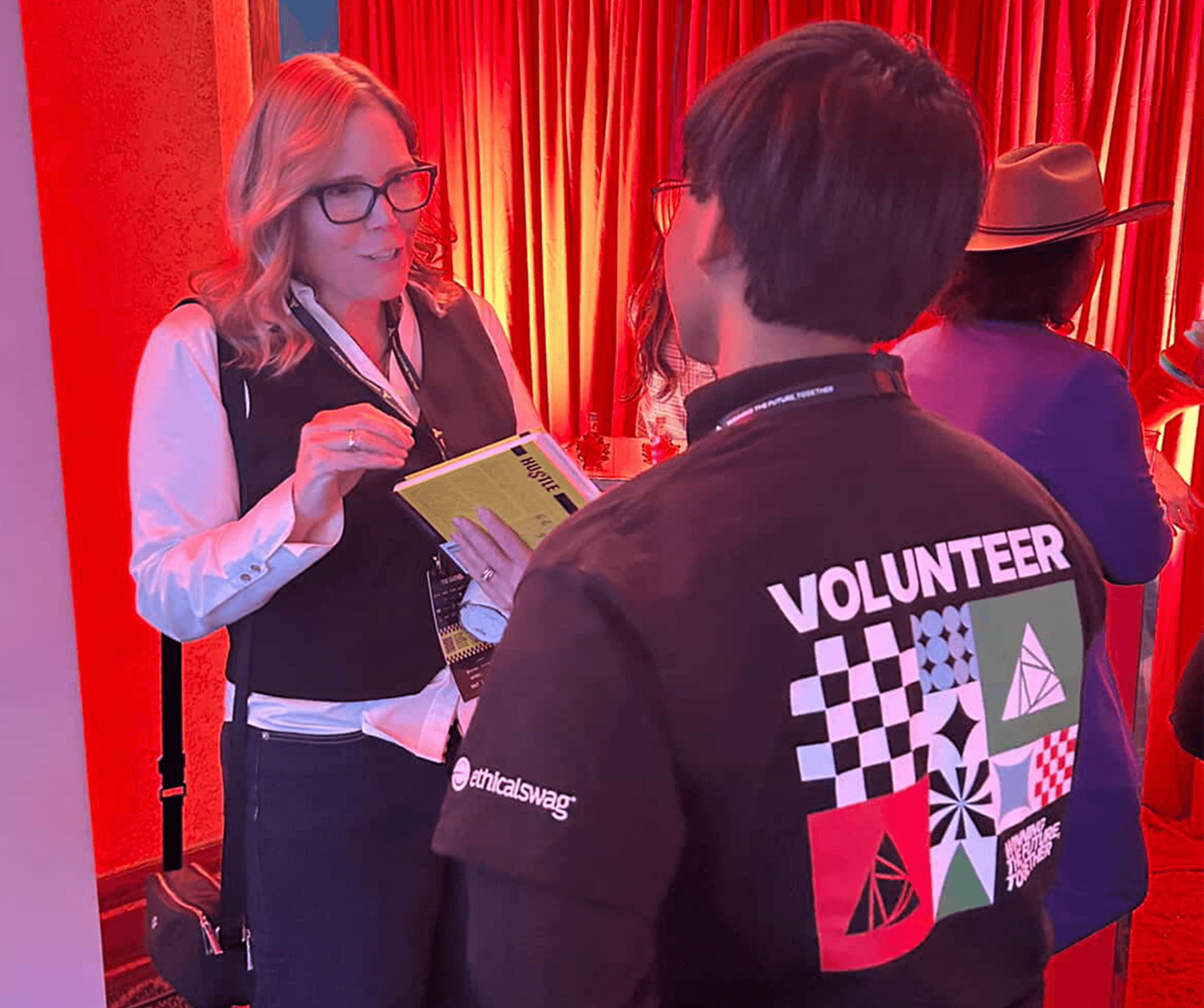 CEO Tara Milburn participating in industry event and talking to a volunteer