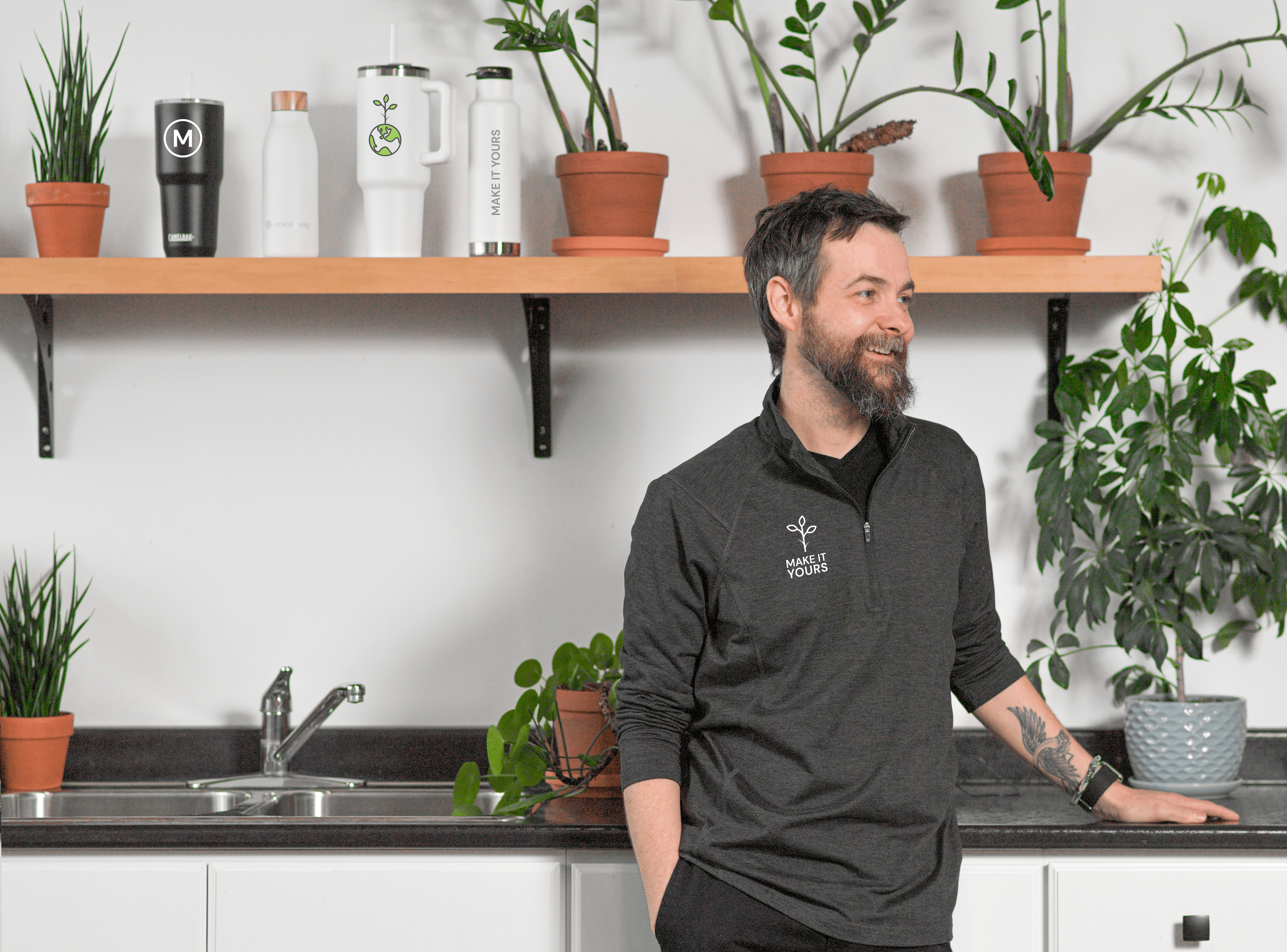 Team member with branded drinkware displayed on a kitchen shelf