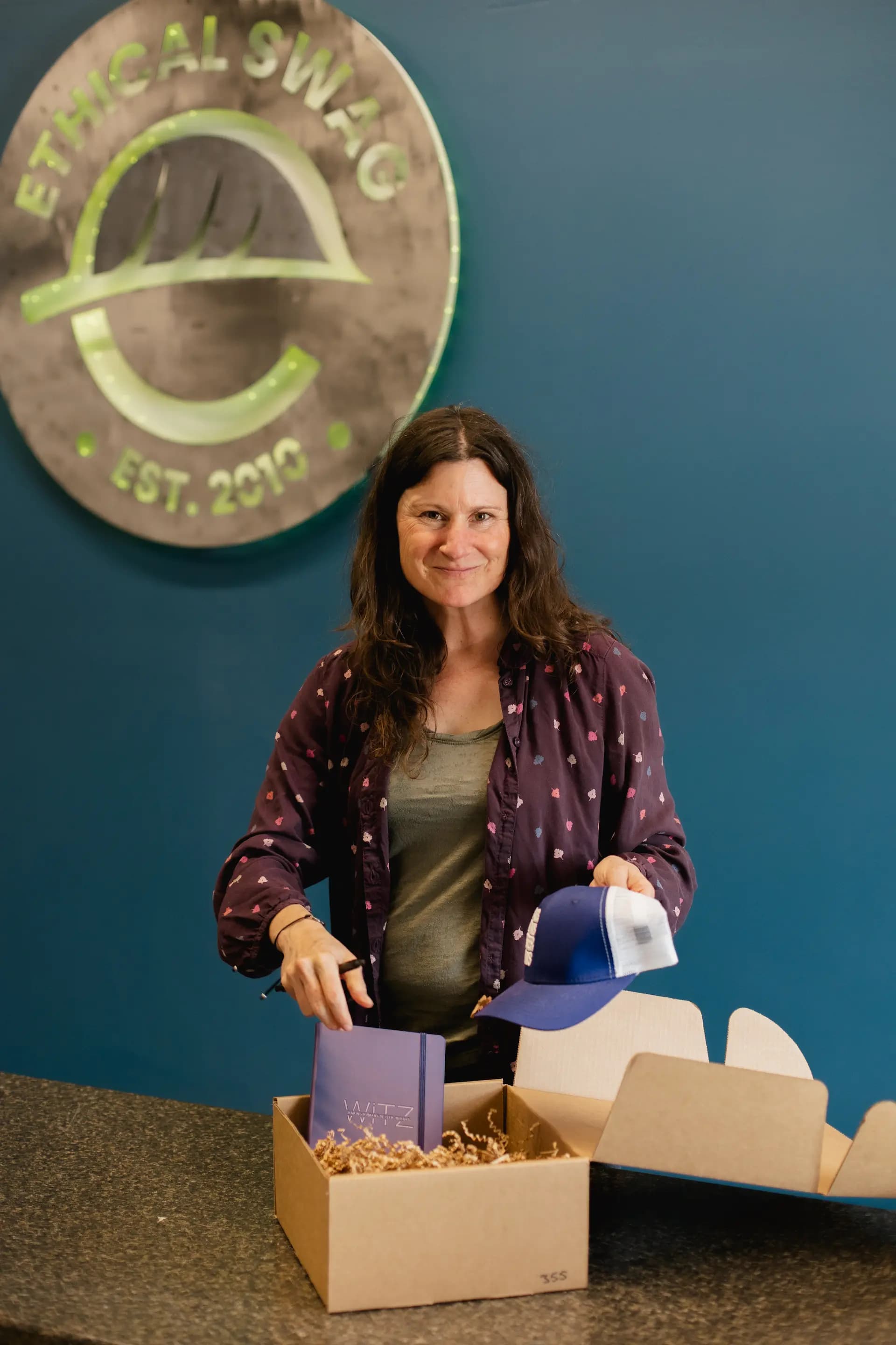 Ethical Swag team member in warehouse with branded merchandise