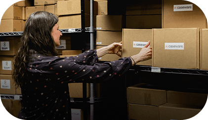 A person working in a warehouse, packaging items into boxes for fulfillment services.
