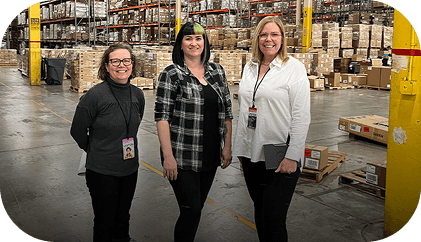 A team standing confidently in a warehouse setting, representing warehousing operations.