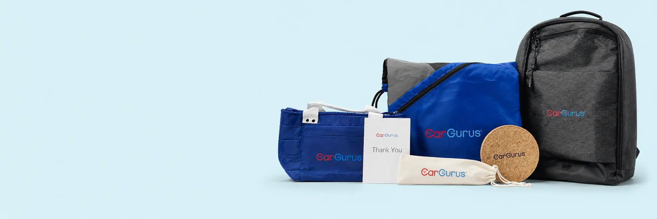 CarGurus-branded backpack, drawstring bag, zippered pouches, and cork coaster from a holiday gift collection
