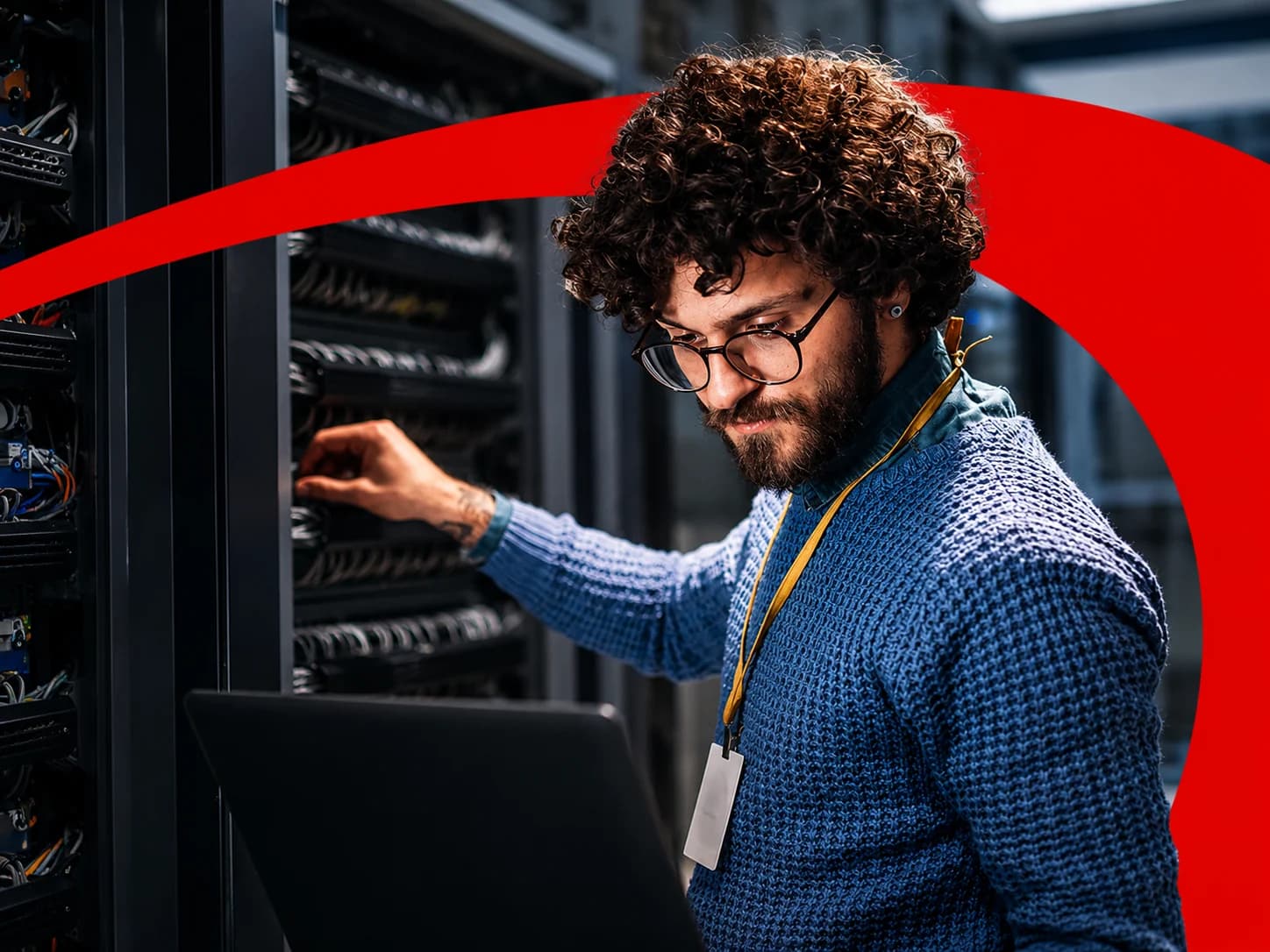 IT professional working on network server racks with a laptop nearby, framed by CDW's red brand accent