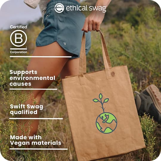 Person holding an ethical swag tote bag outdoors; Certified B Corporation, environmental causes, vegan materials.