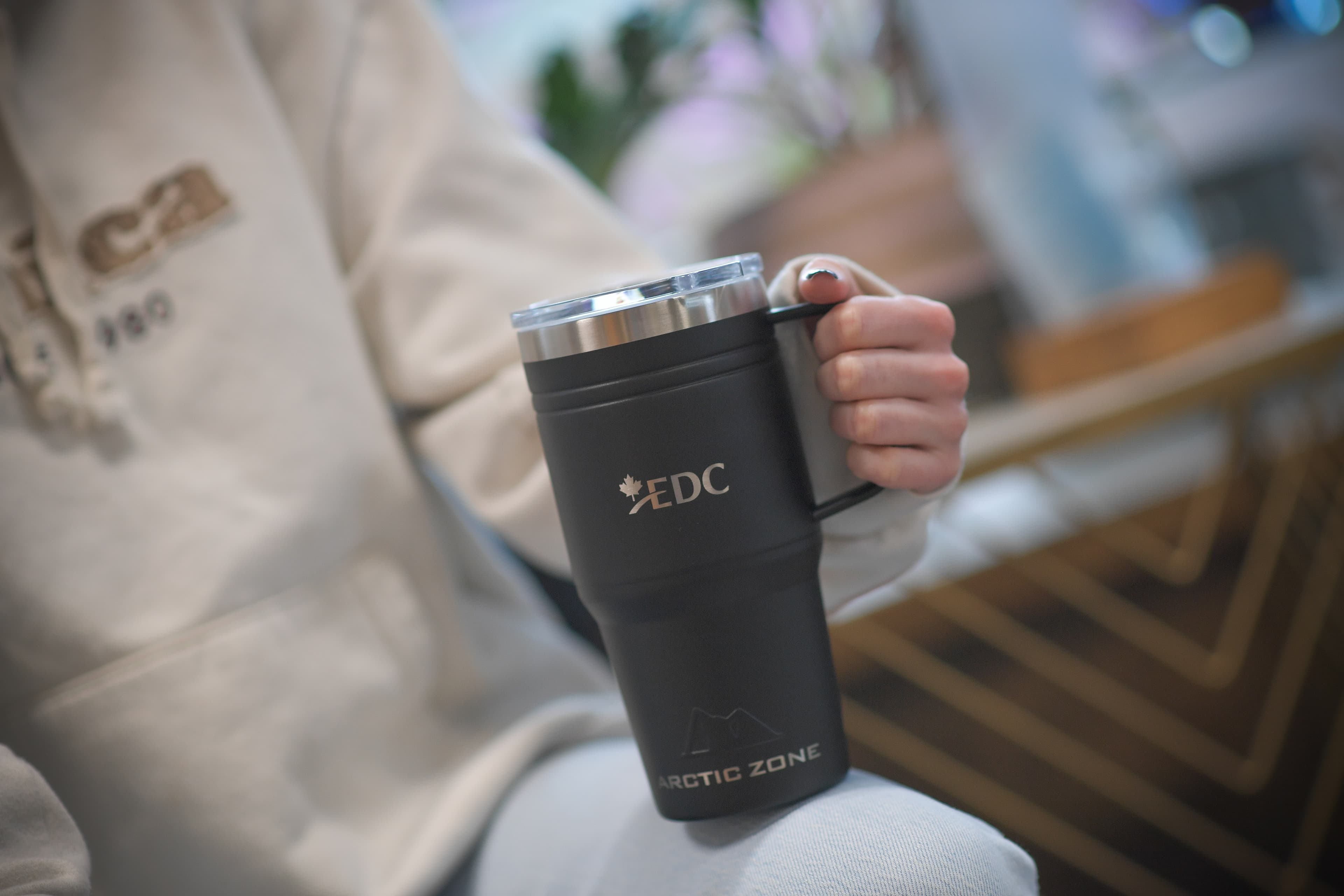 Hand holding a branded EDC tumbler